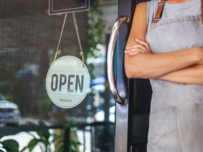 Business Owner next to Open Sign